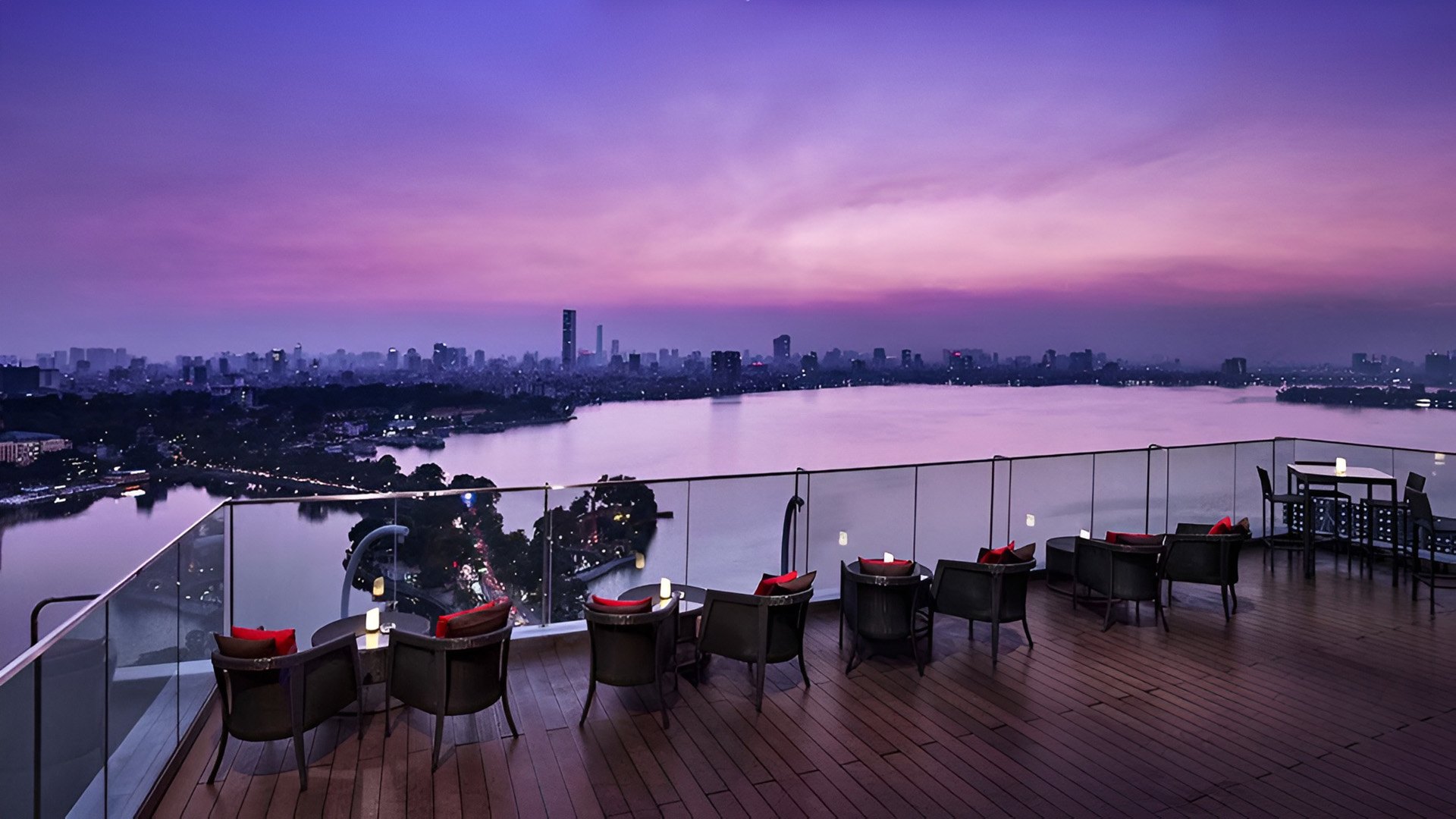 A rooftop terrace at Pan Pacific Hanoi at dusk, West Lake below